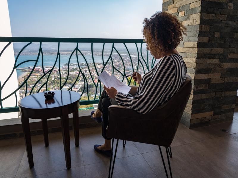 Guest reading on a balcony overlooking the bay