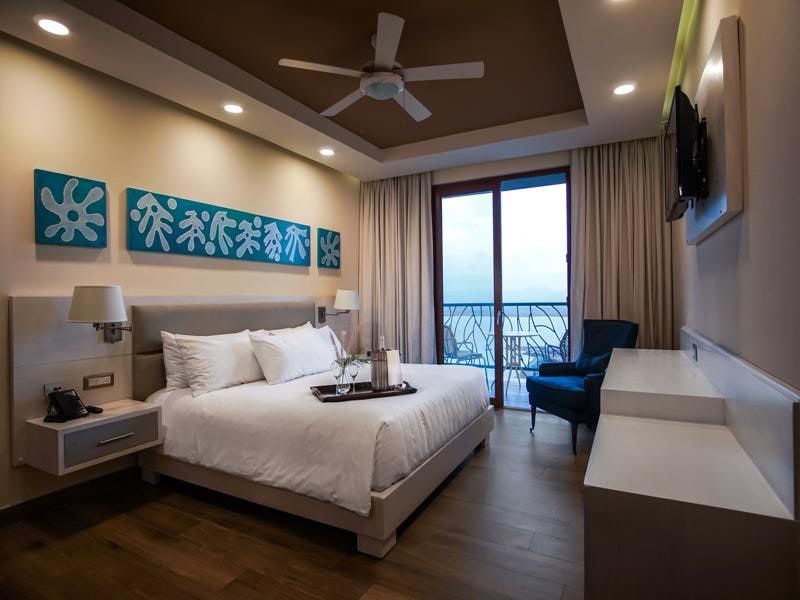 Guest room with king bed, armchair and balcony