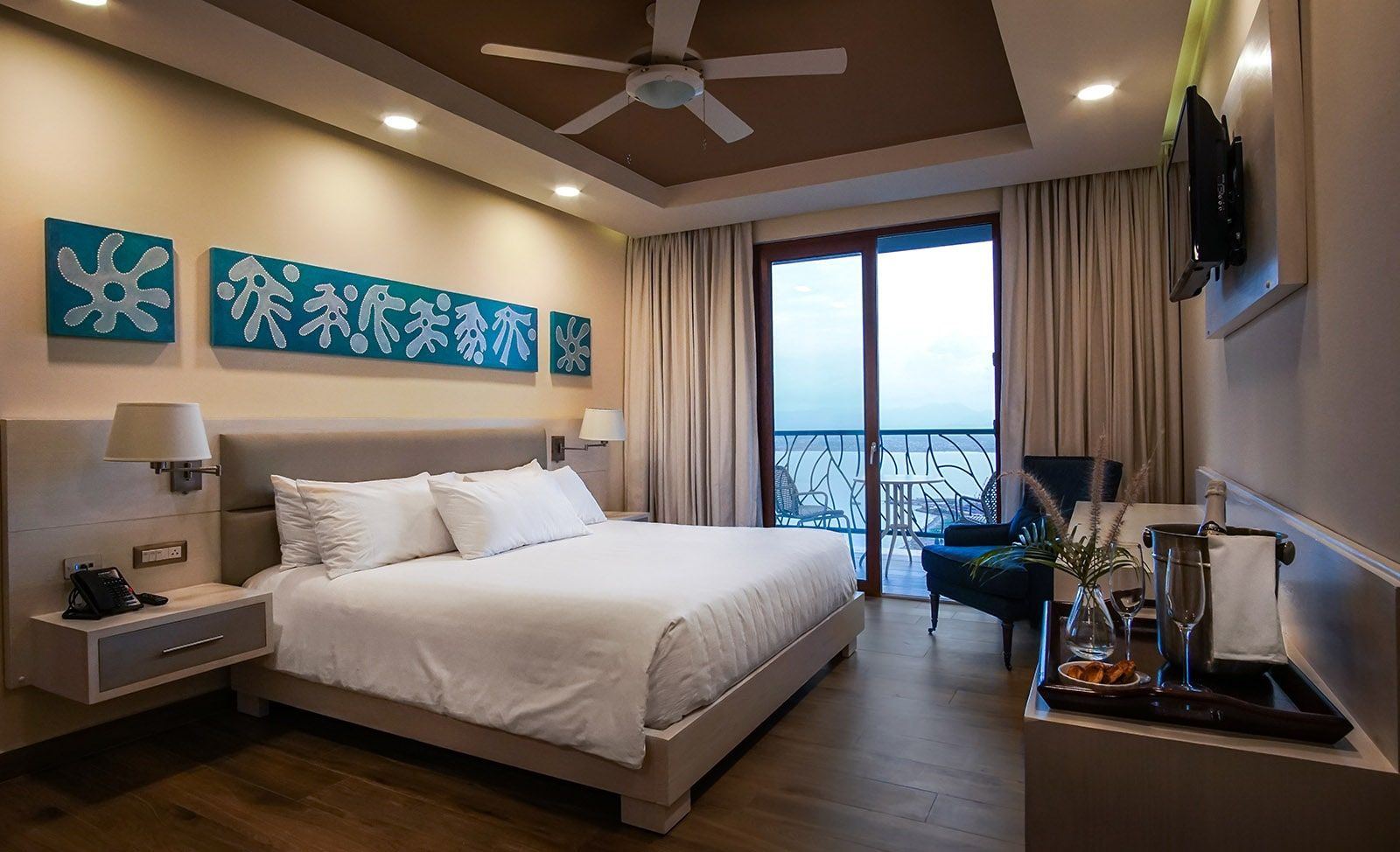 Guest room with king bed and balcony doors open to the view